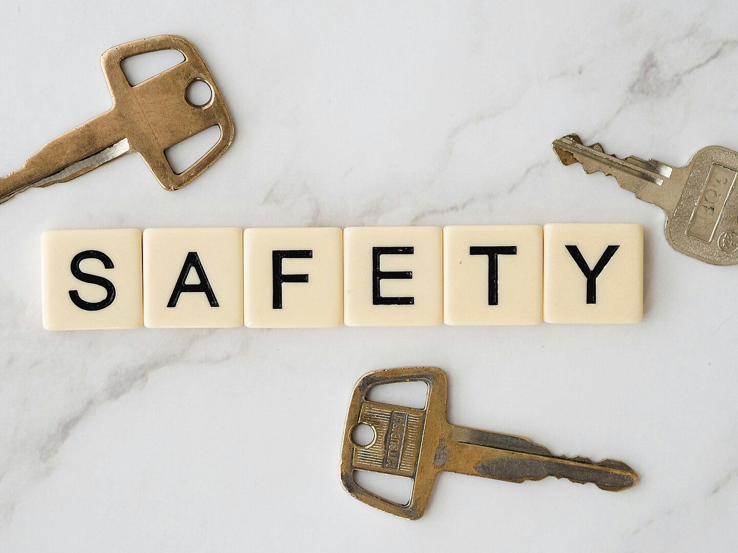 Auf einem Tisch liegen Schlüssel und Buchstaben, die das Wort SAFETY bilden